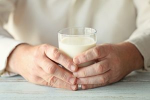 Hände halten ein Glas Milch
