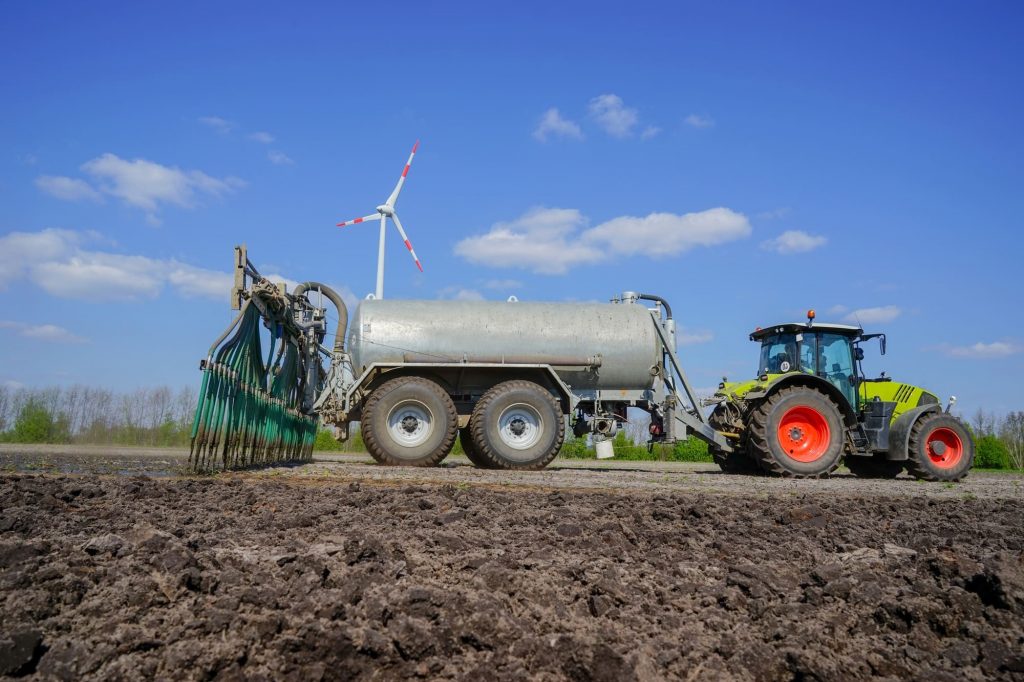 Traktor auf Ackerfeld bei Gülleausbringung