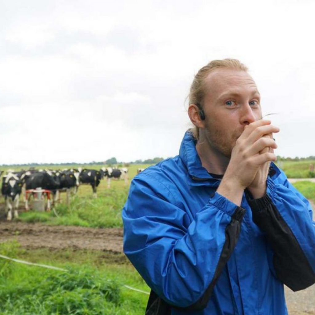 Podcast StadtLandKuh Beauftragter Timo pfeift auf Grashalm vor Kuhweide