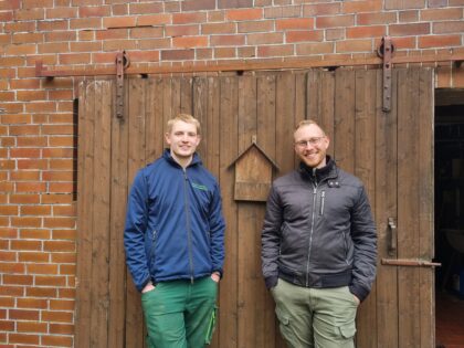 Lars und Timo vor dem Stalltor sprechen über Landwirtschaft