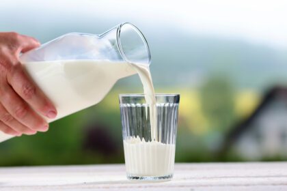 Milch wird in Glas eingeschenkt