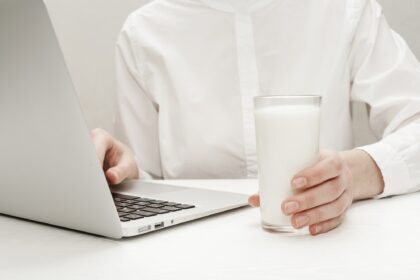 Frau vor Laptop mit einem Glas Milch